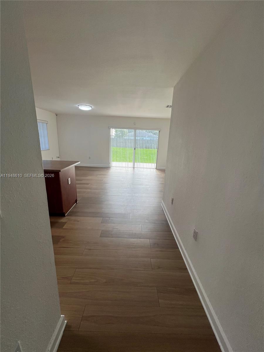 12254 Southwest 217th Street Miami, FL 33170 - Photo 32 of 40 a view of hallway with furniture and wooden floor