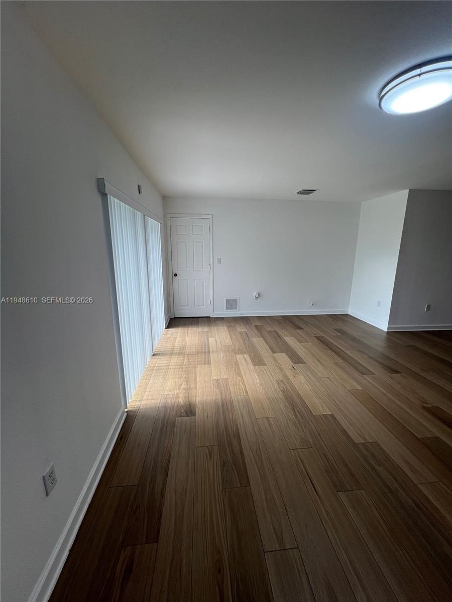 12254 Southwest 217th Street Miami, FL 33170 - Photo 35 of 40 wooden floor in a hall with an empty room