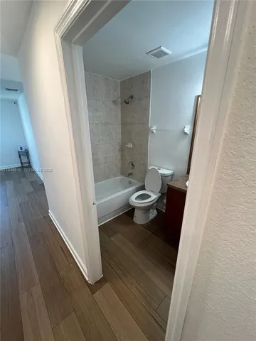 an empty room with wooden floor and closet