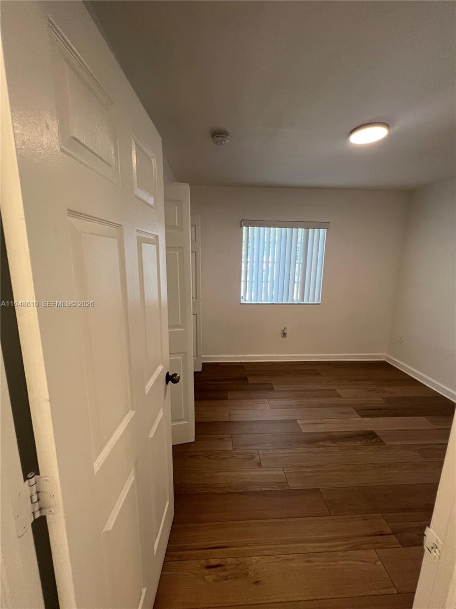 12254 Southwest 217th Street Miami, FL 33170 - Photo 10 of 40 a view of an empty room with wooden floor and a window