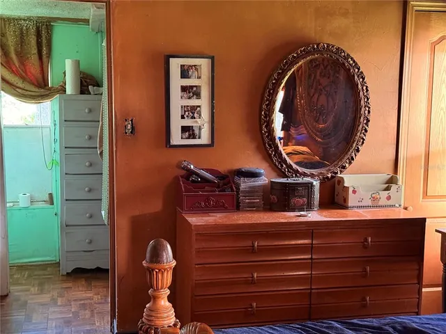 a living room with furniture kitchen view and a wooden floor