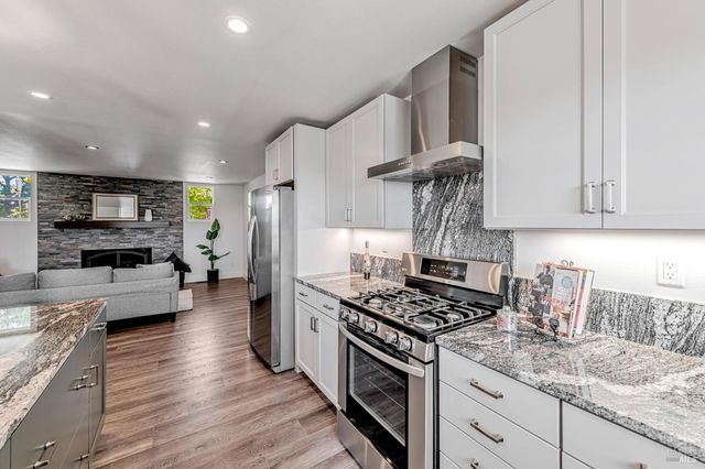 a kitchen with stainless steel appliances granite countertop a sink stove and refrigerator