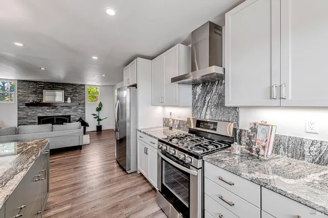 a kitchen with stainless steel appliances granite countertop a sink stove and refrigerator