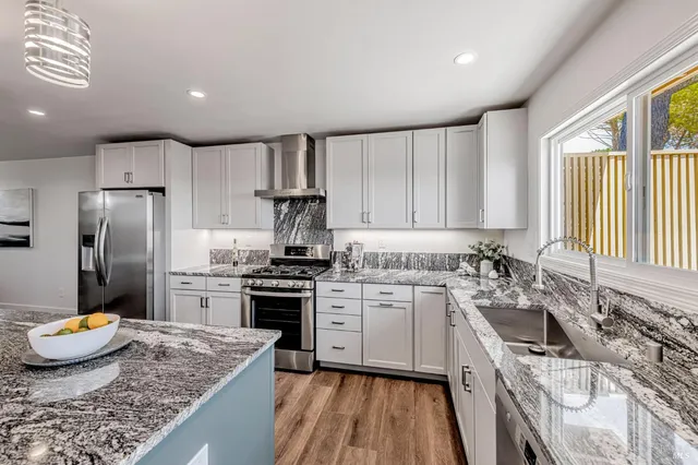 a kitchen with a dining table chairs refrigerator and cabinets