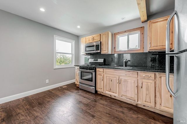 a kitchen with stainless steel appliances granite countertop a refrigerator and a stove top oven