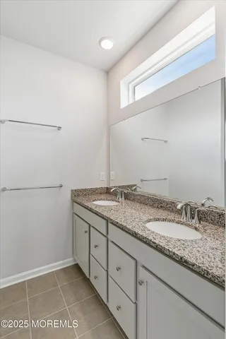 a bathroom with a granite countertop sink and white cabinets