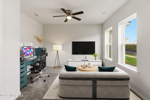 a living room with furniture a flat screen tv and a window
