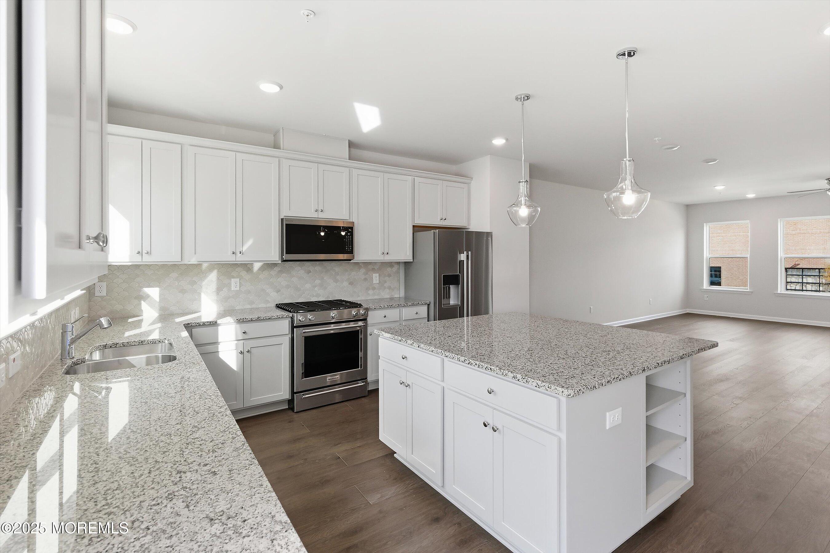 12 Barton Avenue Oceanport, NJ 07757 - Photo 8 of 22 a kitchen with stainless steel appliances kitchen island granite countertop a stove a sink and a microwave