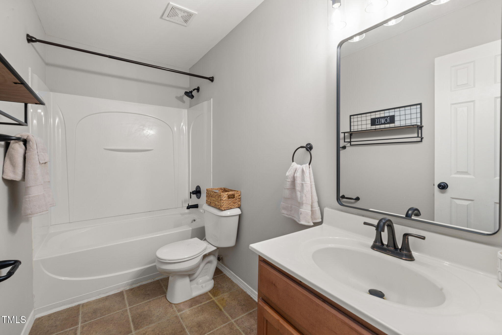 2701 Skybrook Lane Durham, NC 27703 - Photo 10 of 24 a bathroom with a sink a toilet and a mirror