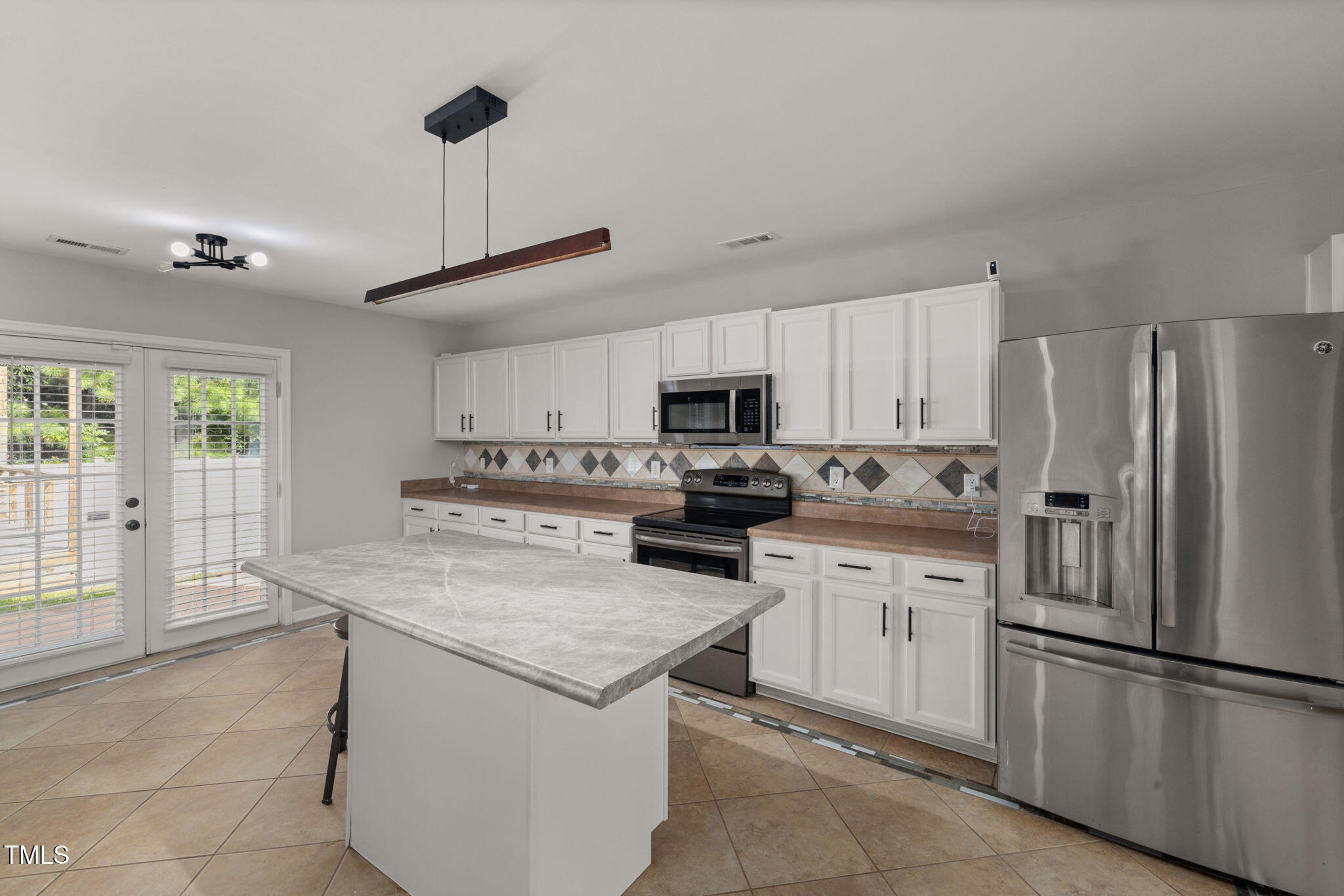 2701 Skybrook Lane Durham, NC 27703 - Photo 5 of 24 a kitchen with white cabinets and stainless steel appliances