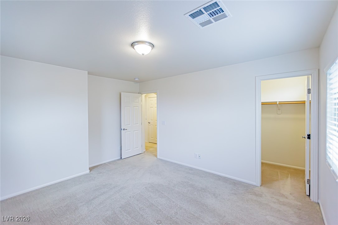 11009 Ketchikan Street Las Vegas, NV 89179 - Photo 32 of 59 Unfurnished bedroom with light colored carpet and a walk in closet