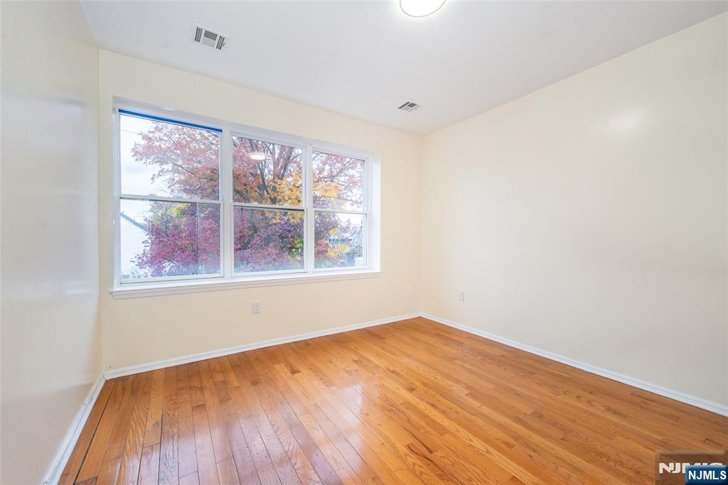 1878 Springfield Avenue, Unit 2B Maplewood, NJ 07040 - Photo 11 of 15 an empty room with wooden floor and windows