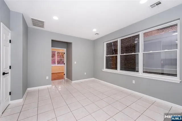 a view of an empty room with window and cabinet