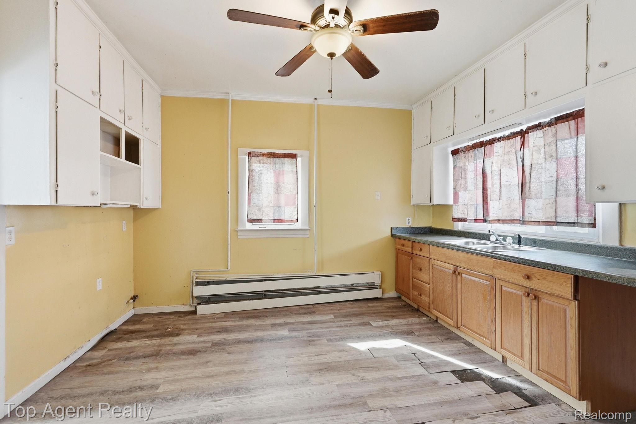 95 West Lapeer Road Peck, MI 48466 - Photo 9 of 33 Kitchen with ceiling fan, light wood-style floors, a baseboard radiator, plenty of natural light, and ornamental molding