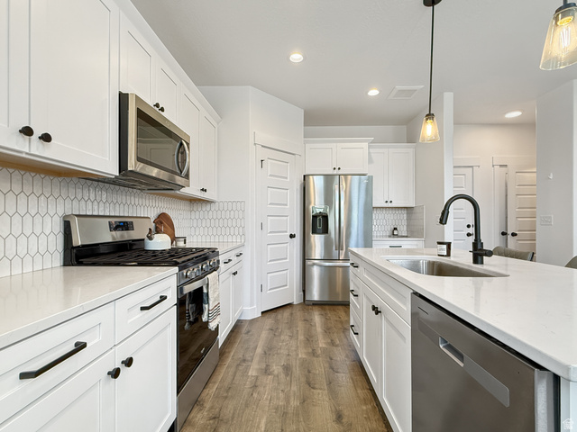 641 Desert Willow Drive Mapleton, UT 84664 - Photo 10 of 41 Kitchen featuring stainless steel appliances, light stone counters, and white cabinets