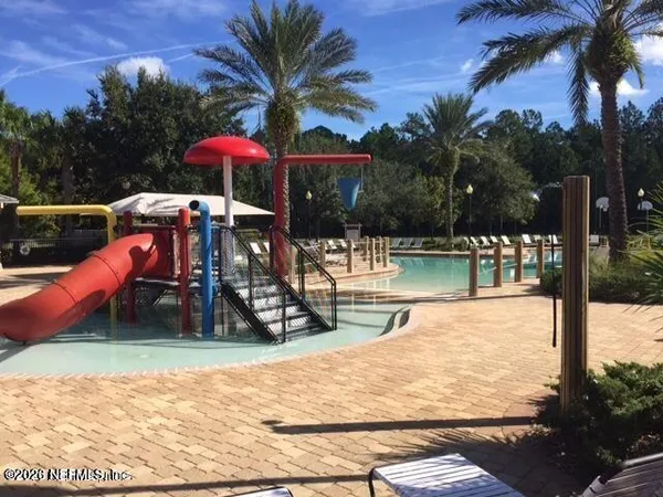 a view of a swimming pool with a lounge chair and tables