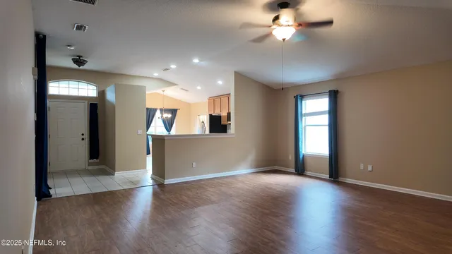 a kitchen with windows and a refrigerator