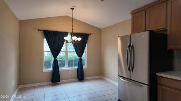 a kitchen with windows and a refrigerator
