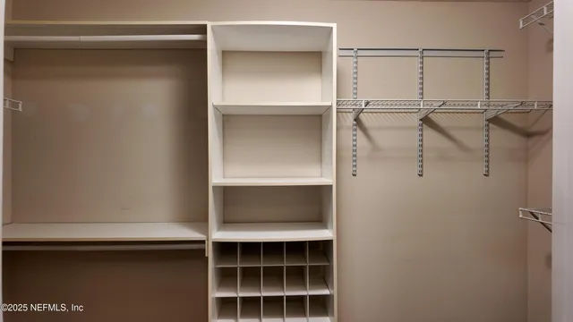 a view of walk in closet with empty racks