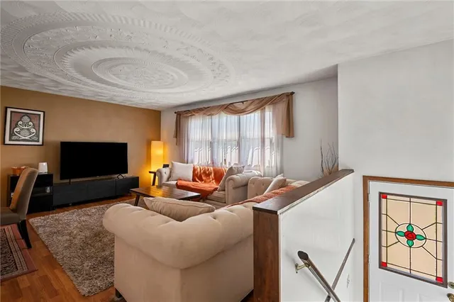 a living room with furniture a flat screen tv and a large window