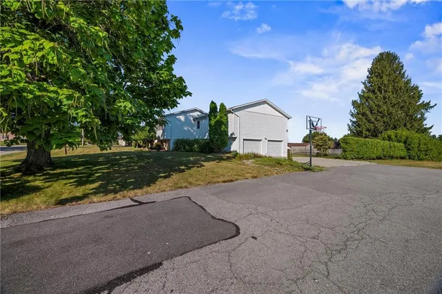 a view of a house with a yard and large trees
