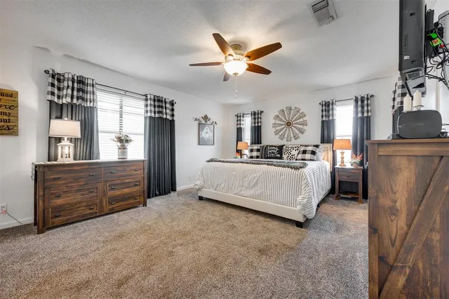 a spacious bedroom with a bed and a television