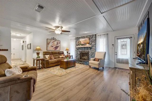 a kitchen with stainless steel appliances kitchen island granite countertop a stove a refrigerator and a wooden cabinets