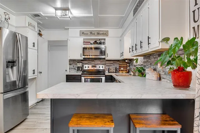 a kitchen with stainless steel appliances a stove a sink and a refrigerator