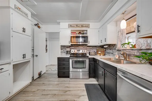 a kitchen with stainless steel appliances granite countertop a sink and stove top oven