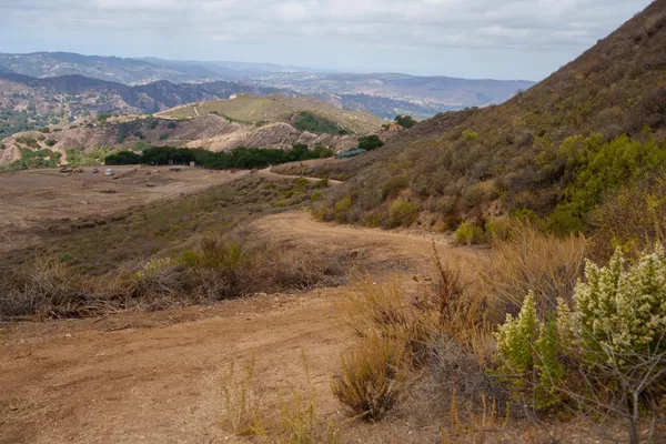 a view of a dry yard with mountains in the background