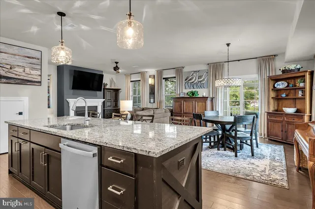 a kitchen with stainless steel appliances granite countertop wooden floors and view living room