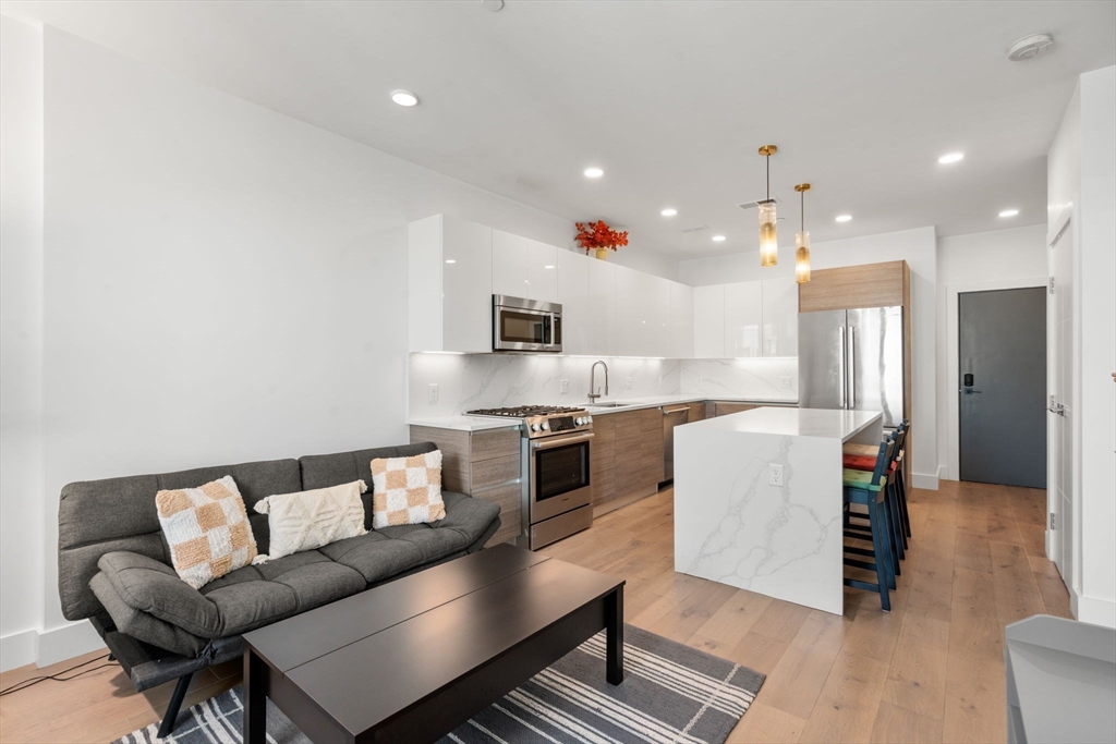 30 Penniman Road, Unit 506 Boston, MA 02134 - Photo 11 of 25 a living room with furniture and kitchen view