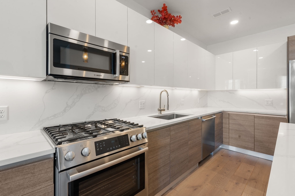 30 Penniman Road, Unit 506 Boston, MA 02134 - Photo 12 of 25 a kitchen with a stove and a microwave