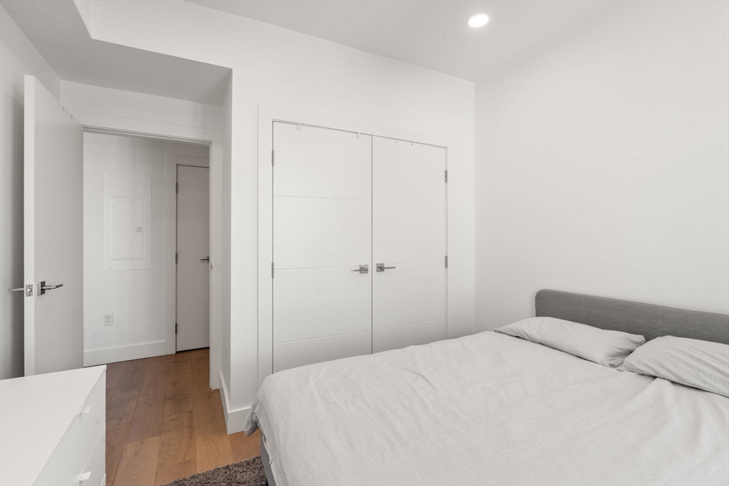 30 Penniman Road, Unit 506 Boston, MA 02134 - Photo 14 of 25 a bedroom with a bed and a mirror
