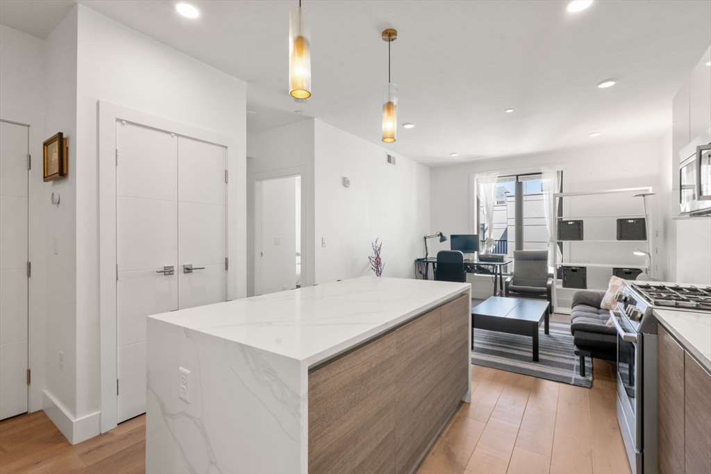 30 Penniman Road, Unit 506 Boston, MA 02134 - Photo 5 of 25 a large room with a lot of white furniture and a wooden floor