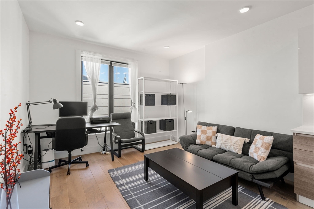 30 Penniman Road, Unit 506 Boston, MA 02134 - Photo 8 of 25 a view of a livingroom with workspace and a couch