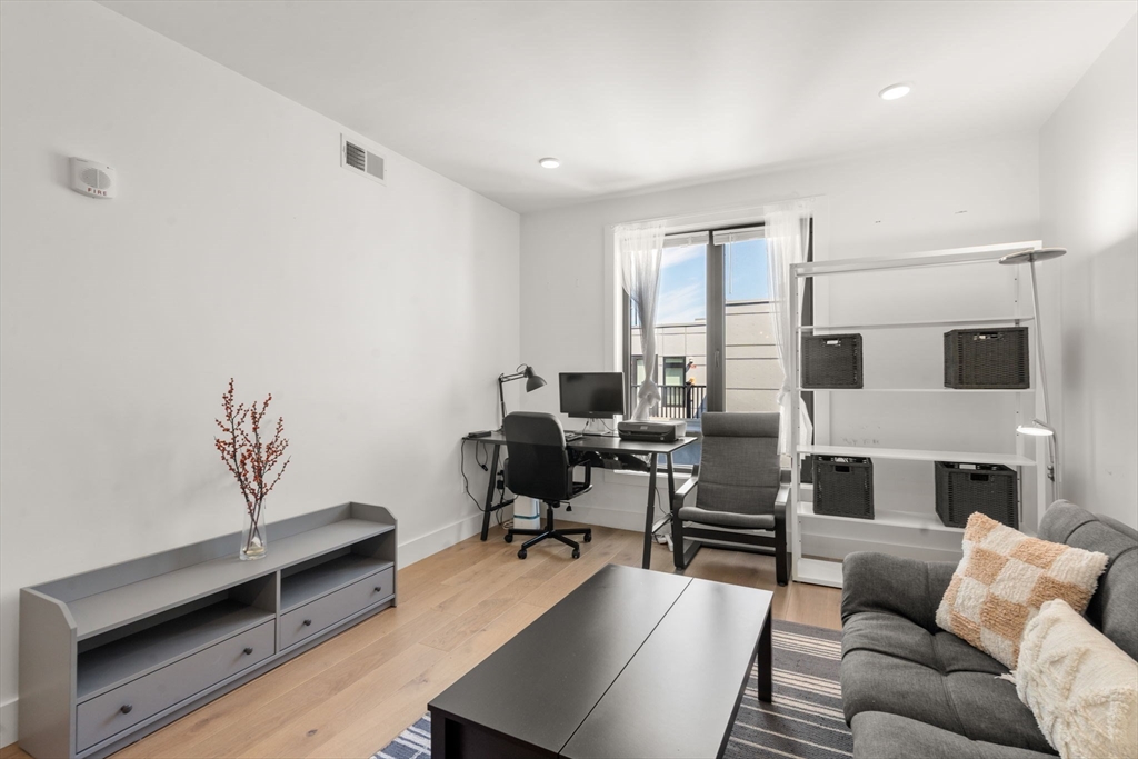 30 Penniman Road, Unit 506 Boston, MA 02134 - Photo 9 of 25 a living room with furniture flat screen tv and a fireplace