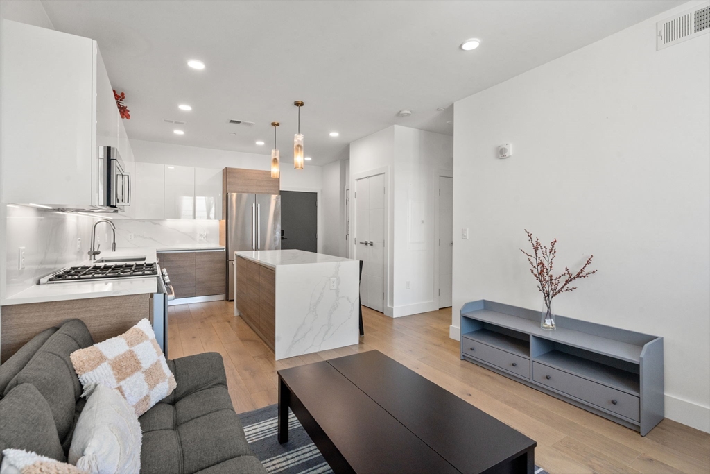 30 Penniman Road, Unit 506 Boston, MA 02134 - Photo 10 of 25 a living room with furniture and a kitchen