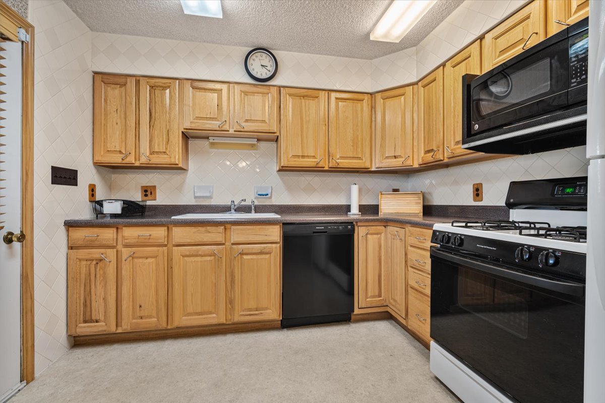 13310 Tango Road Bloomington, IL 61705 - Photo 8 of 40 a kitchen with stainless steel appliances granite countertop a stove a sink and a microwave