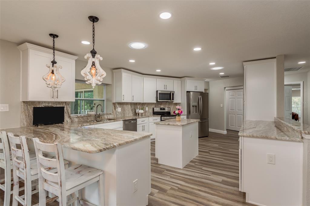 5534 Tropic Drive New Port Richey, FL 34653 - Photo 12 of 32 a kitchen with kitchen island a stove a table and chairs