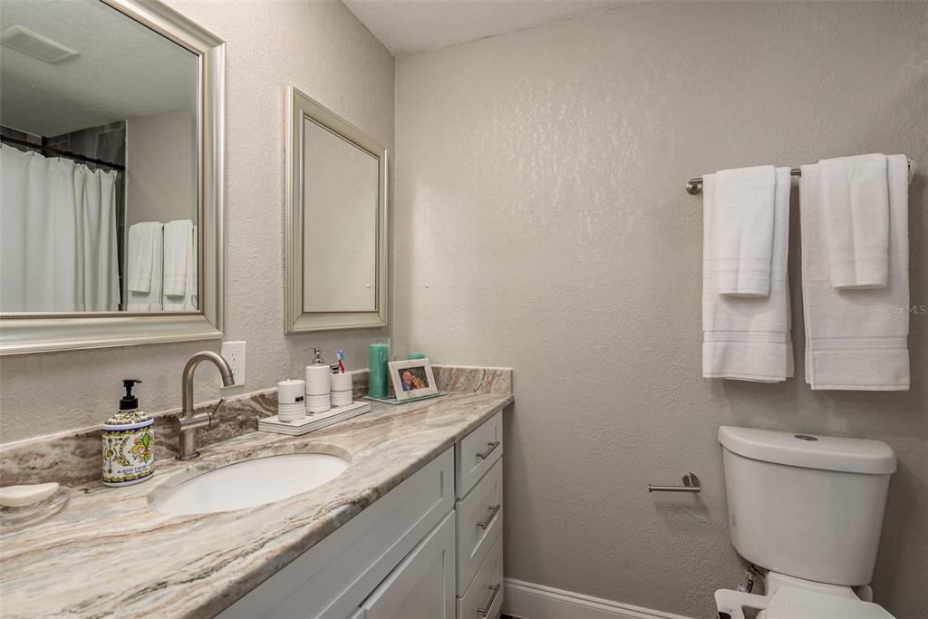 5534 Tropic Drive New Port Richey, FL 34653 - Photo 17 of 32 a bathroom with a granite countertop toilet sink and mirror