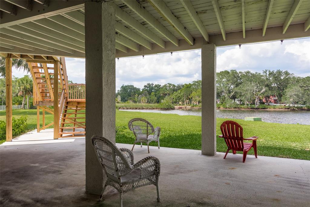 5534 Tropic Drive New Port Richey, FL 34653 - Photo 24 of 32 a view of a porch with a table chairs and a yard