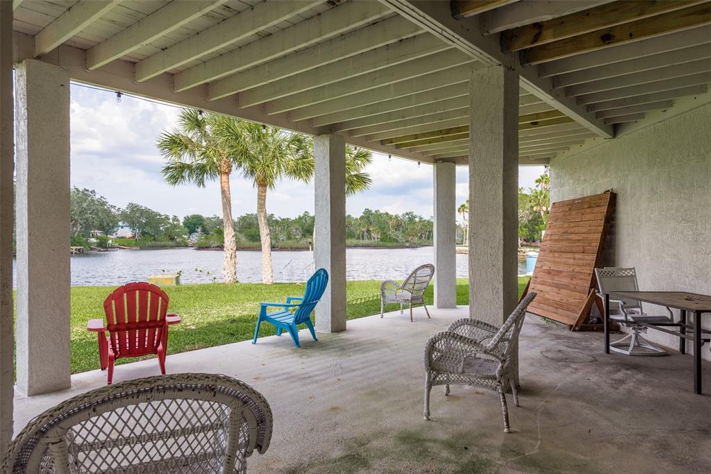 5534 Tropic Drive New Port Richey, FL 34653 - Photo 25 of 32 a view of a patio with a table chairs and a backyard