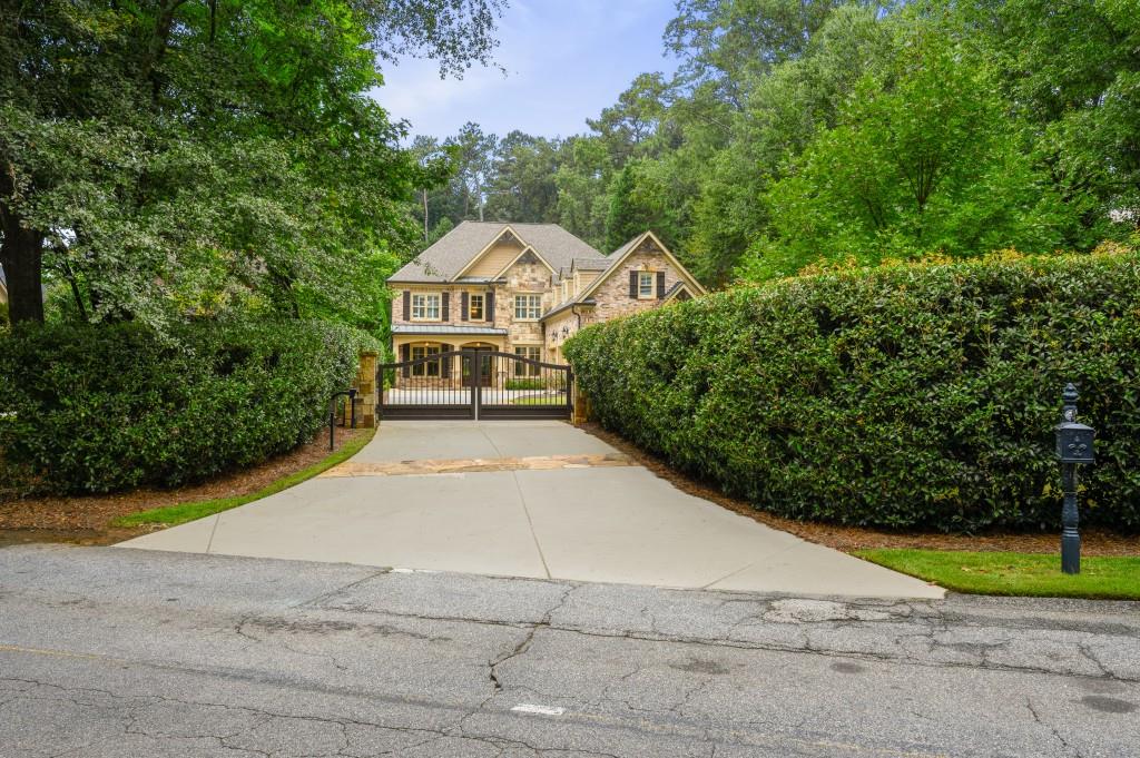 a view of a large house with large trees and plants
