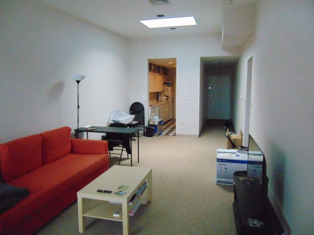 10 Weston Avenue, Unit 430 Quincy, MA 02170 - Photo 5 of 9 a living room with furniture and a mirror
