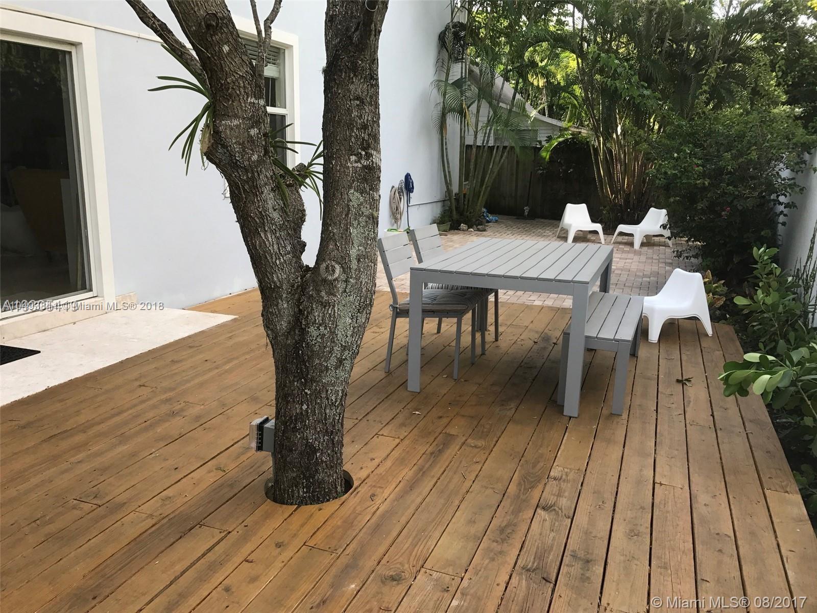 2980 Virginia Street, Unit 2980 Miami, FL 33133 - Photo 16 of 17 a view of a patio with table and chairs with wooden floor and fence