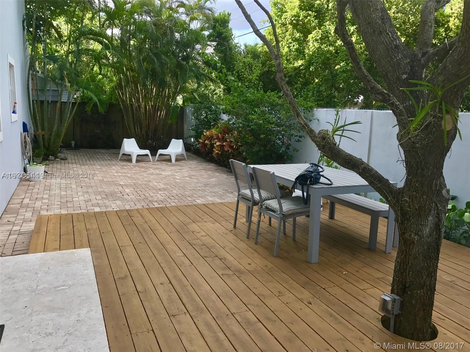 2980 Virginia Street, Unit 2980 Miami, FL 33133 - Photo 17 of 17 a view of a patio with table and chairs with wooden floor and fence