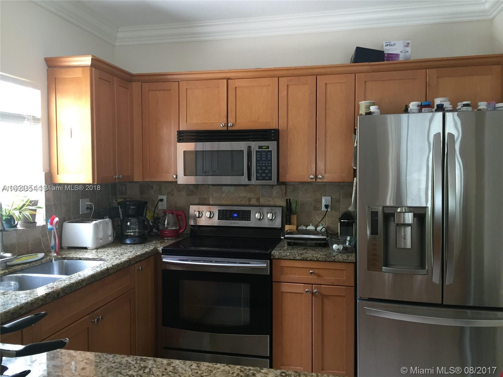 2980 Virginia Street, Unit 2980 Miami, FL 33133 - Photo 6 of 17 a kitchen with granite countertop a refrigerator stove and microwave