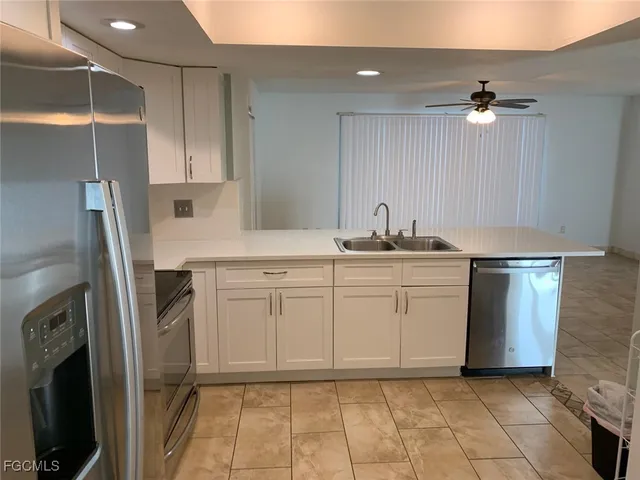 a kitchen with a sink refrigerator and microwave