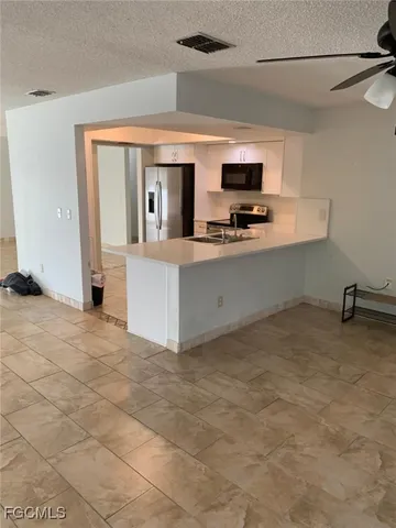 a view of kitchen with stainless steel appliances cabinets